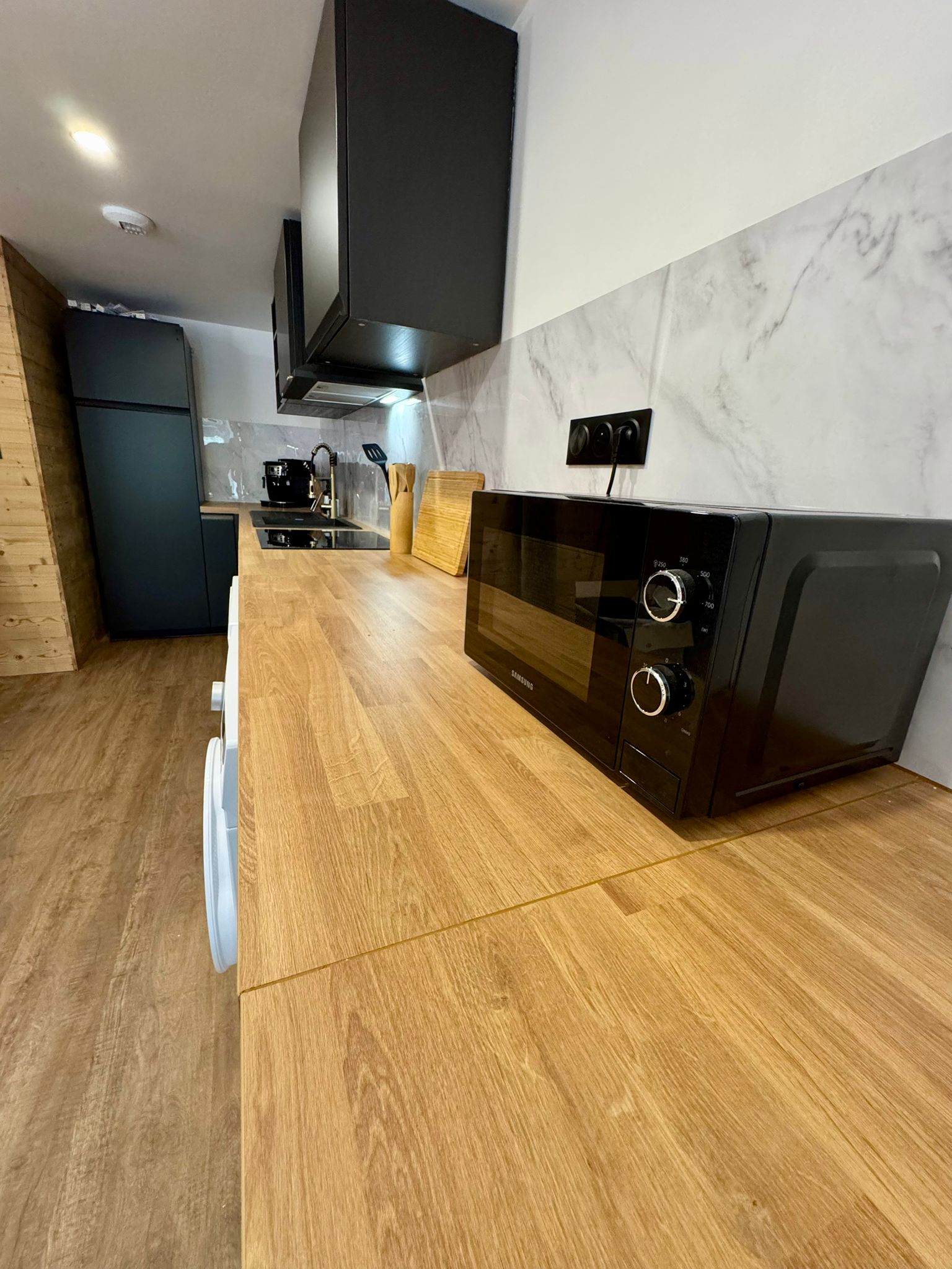 Salon avec parquet bois et éclairage tamisé