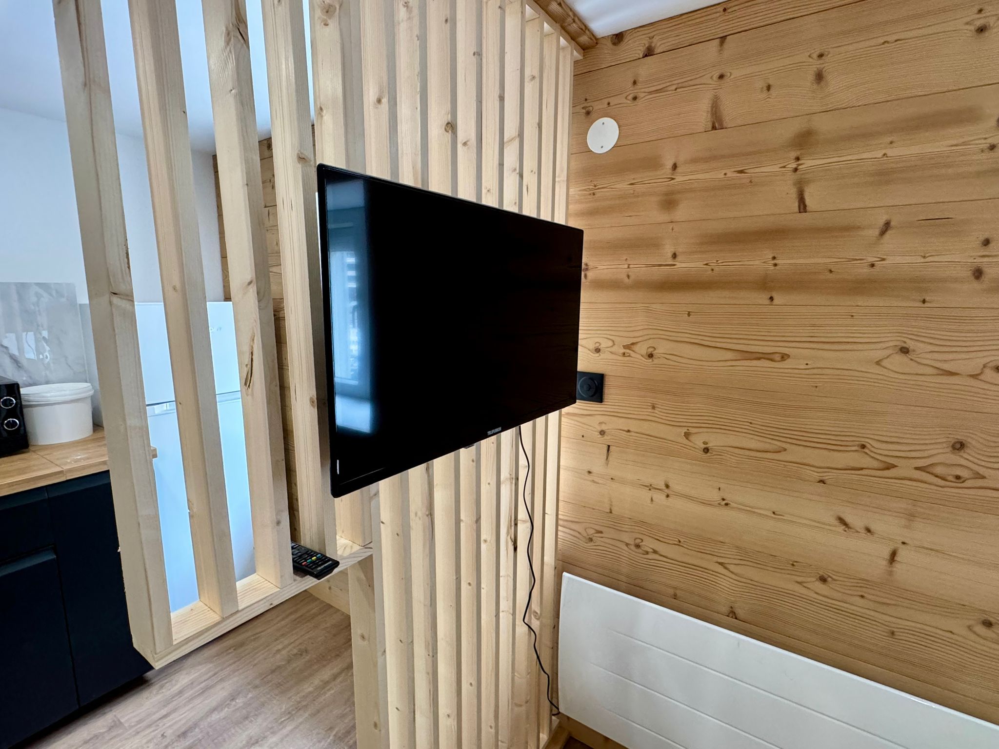 Smart TV sur mur en lattes de bois dans le salon